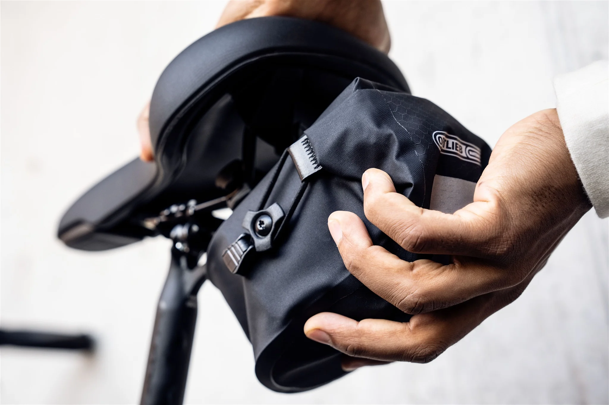 ORTLIEB Micro-Bag in dark-sand am Fahrradsattel montiert im natürlichen Umfeld